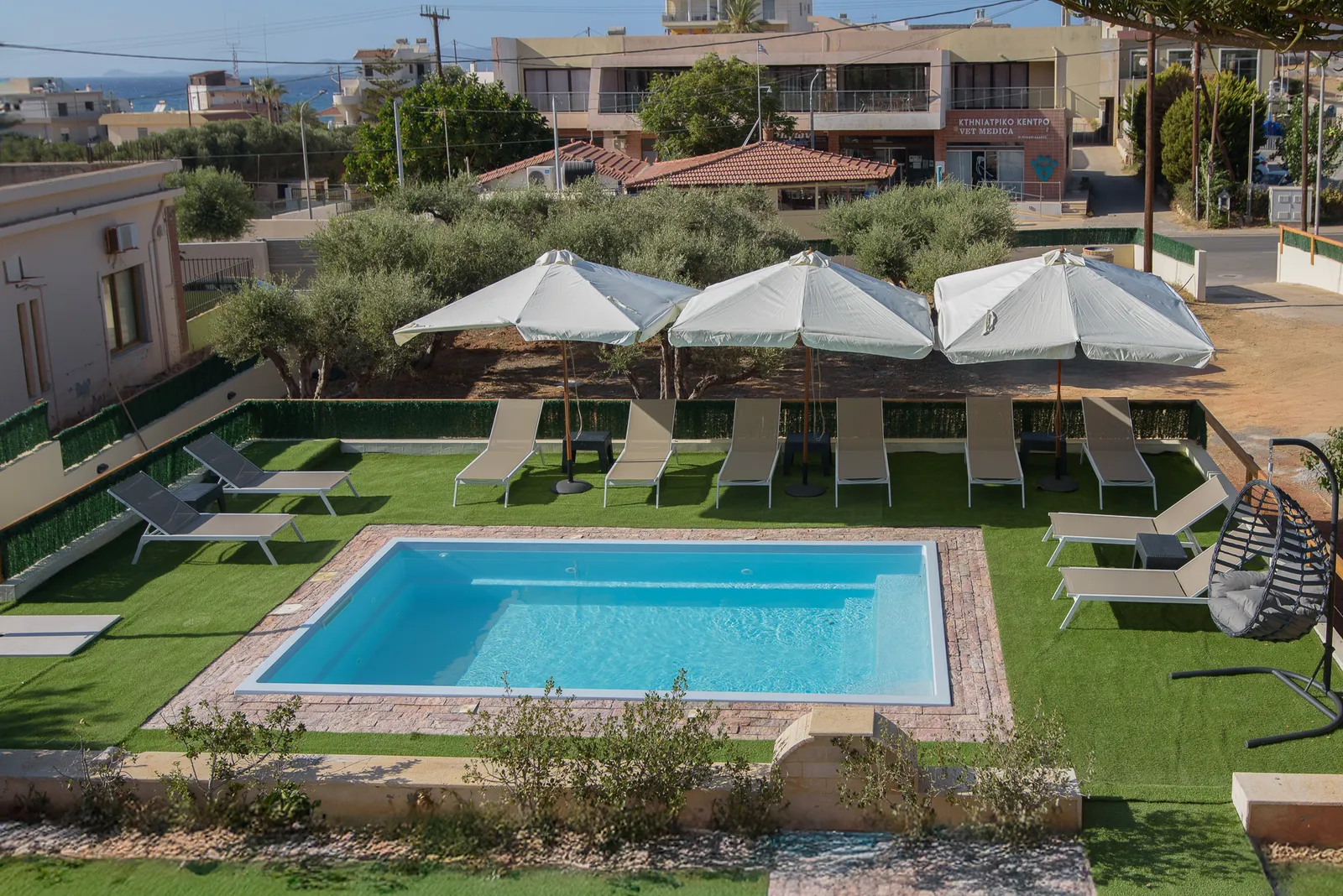 Pool und Garten der Villa Haris mit Liegen und Olivenbäumen